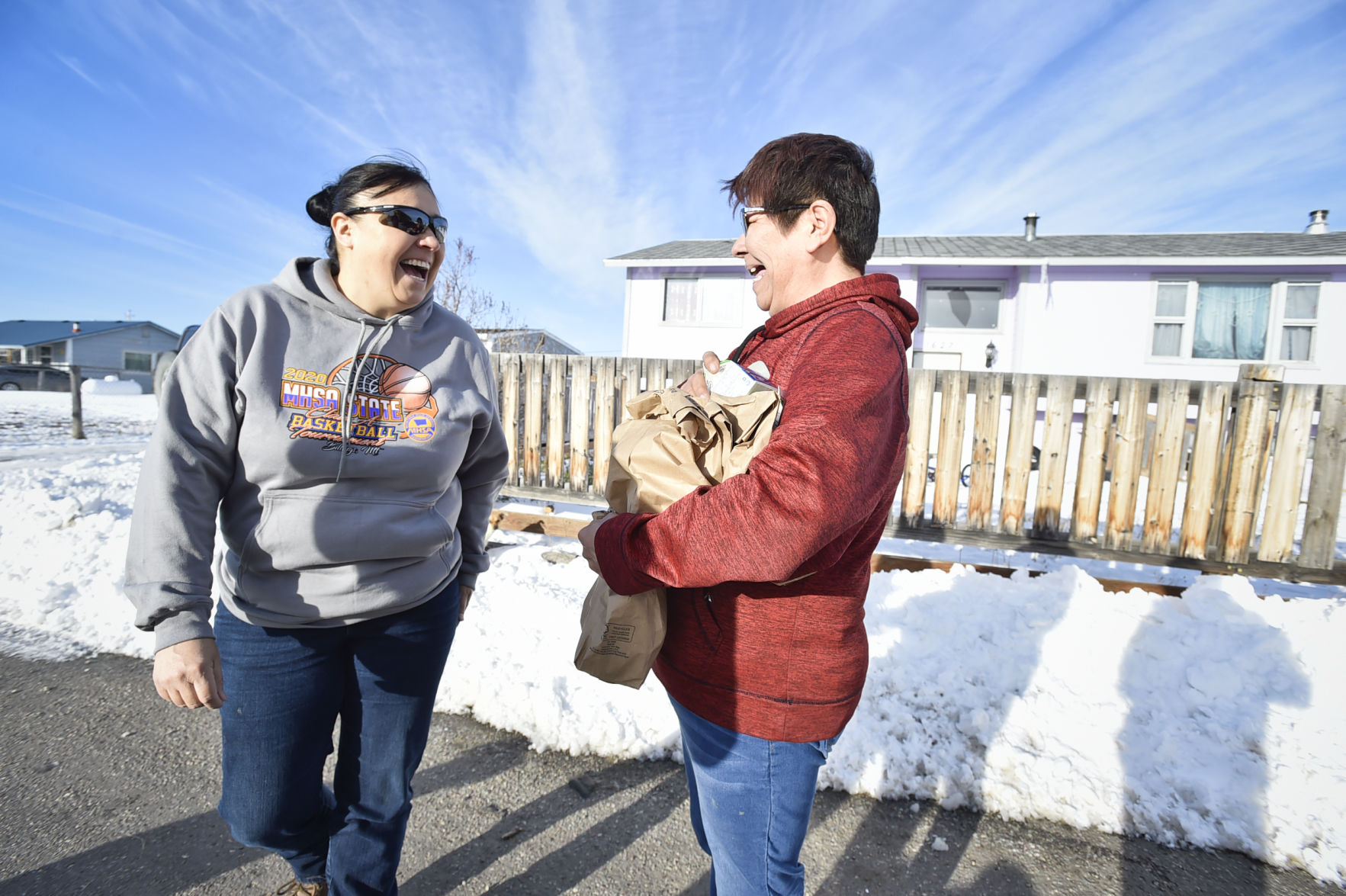 Nicklo Crossguns, left, laughs with Cherie Bear Medicine